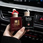 Two hanging BYD car air freshener perfume bottles inside a modern vehicle interior