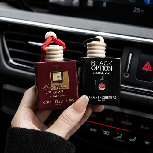 Two hanging BYD car air freshener perfume bottles inside a modern vehicle interior