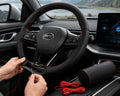 Black genuine leather steering wheel cover with red stitching installed inside a modern BYD car interior