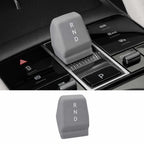 Car gear shift lever with 'RND' marking, shown in a car interior setting.