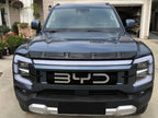 BYD Shark 6 parked in front of a home with gloss black hood shield deflector installed
