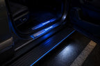 BYD Shark 6 illuminated LED door sill strip lights glowing blue at night inside vehicle entry area