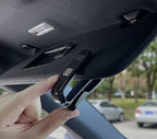 byd Hand holding a car visor clip with a blurred outdoor background