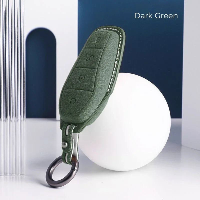 Dark green leather key fob cover with precise stitching and metal ring